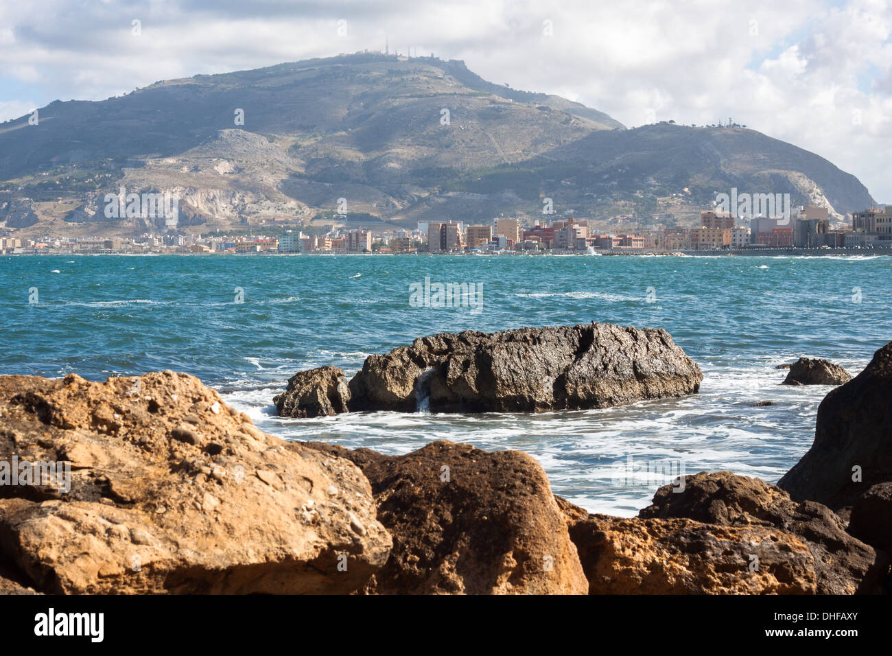 View over rocks of 'Mediterranean sea' blue sea stones mountain [Erice mountain] 'city view' town, close-up Stock Photo