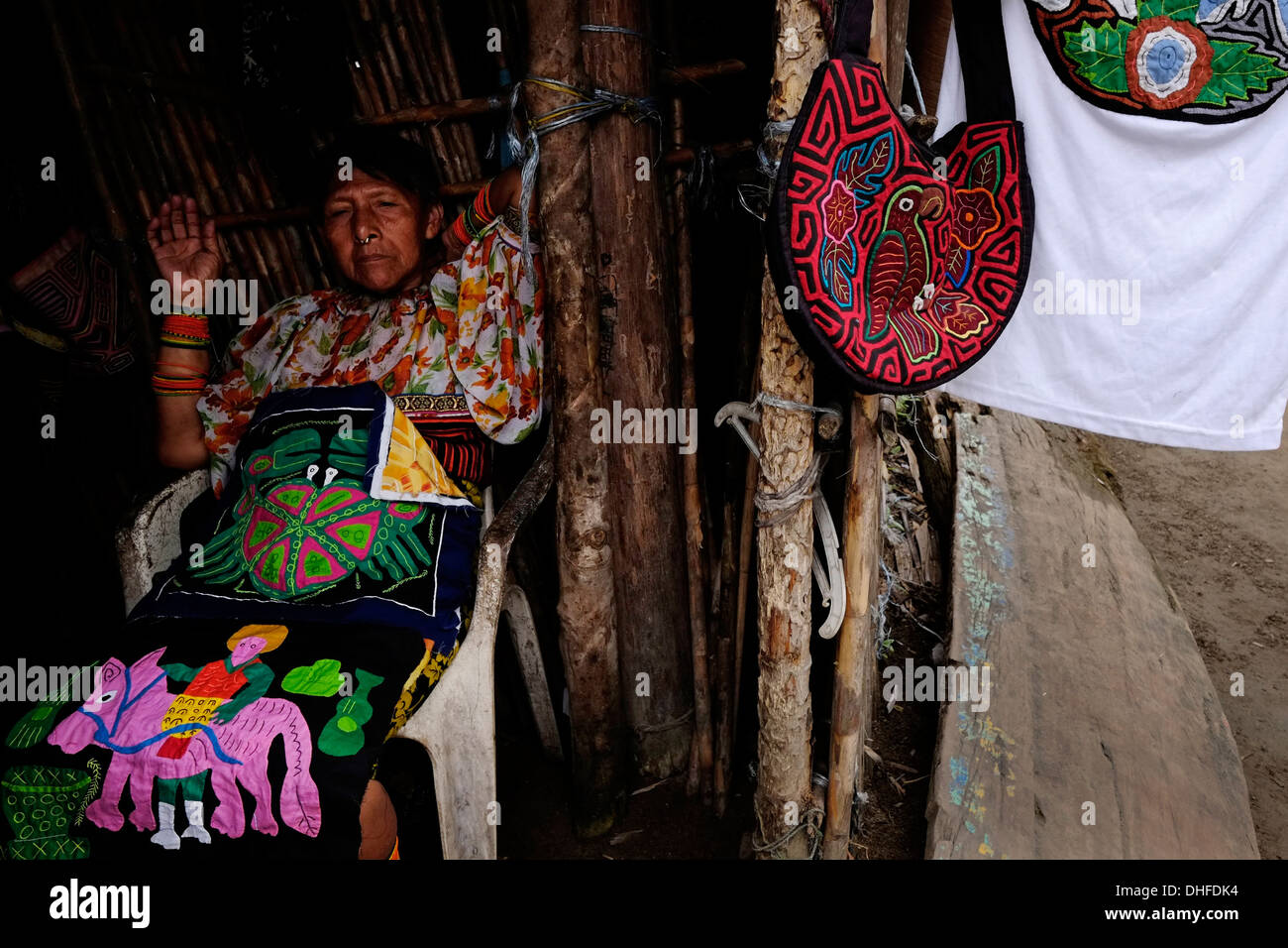 A woman from the Guna people displays a selection of traditional hand-made molas for sale at her home in Carti Sugtupu island village administered by Guna natives known as Kuna in the 'Comarca' (region) of the Guna Yala located in the archipelago of San Blas Blas islands in the Northeast of Panama facing the Caribbean Sea. Stock Photo