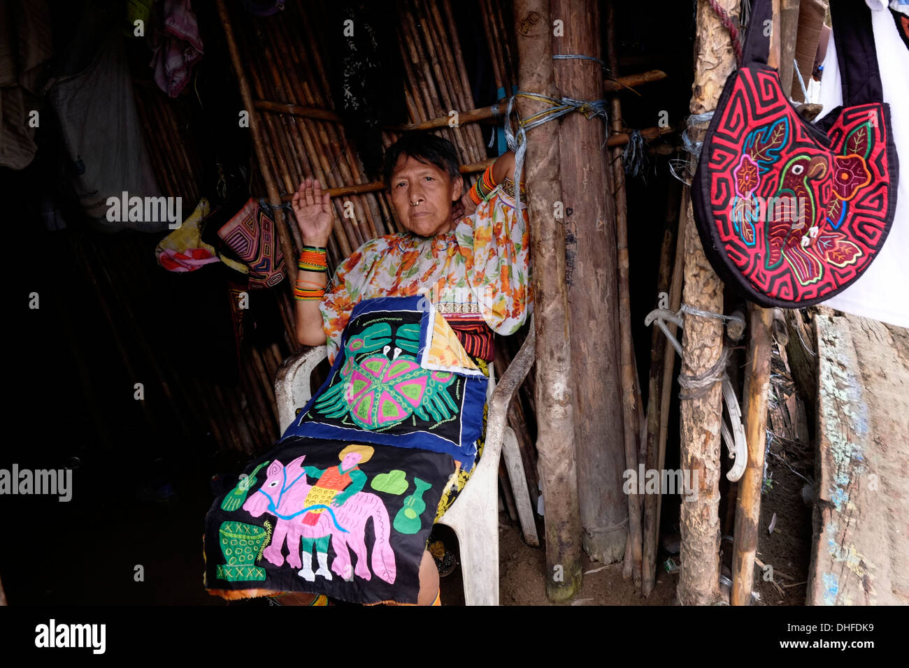 A woman from the Guna people displays a selection of traditional hand-made molas for sale at her home in Carti Sugtupu island village administered by Guna natives known as Kuna in the 'Comarca' (region) of the Guna Yala located in the archipelago of San Blas Blas islands in the Northeast of Panama facing the Caribbean Sea. Stock Photo