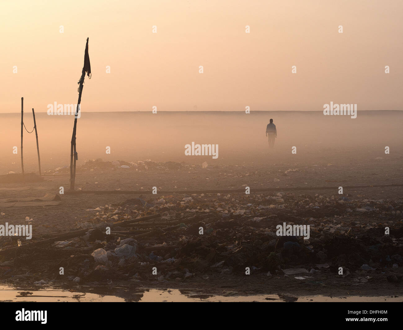 Man walking on the dusty and desolate East bank of the Ganges river in Varanasi, India. Stock Photo