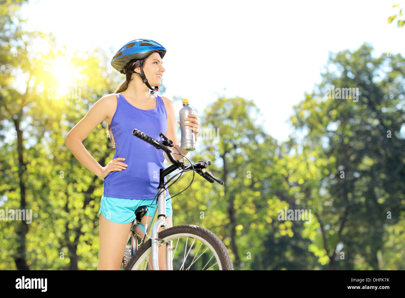 Young female biker posing on a bike outdoor on a sunny day Stock Photo
