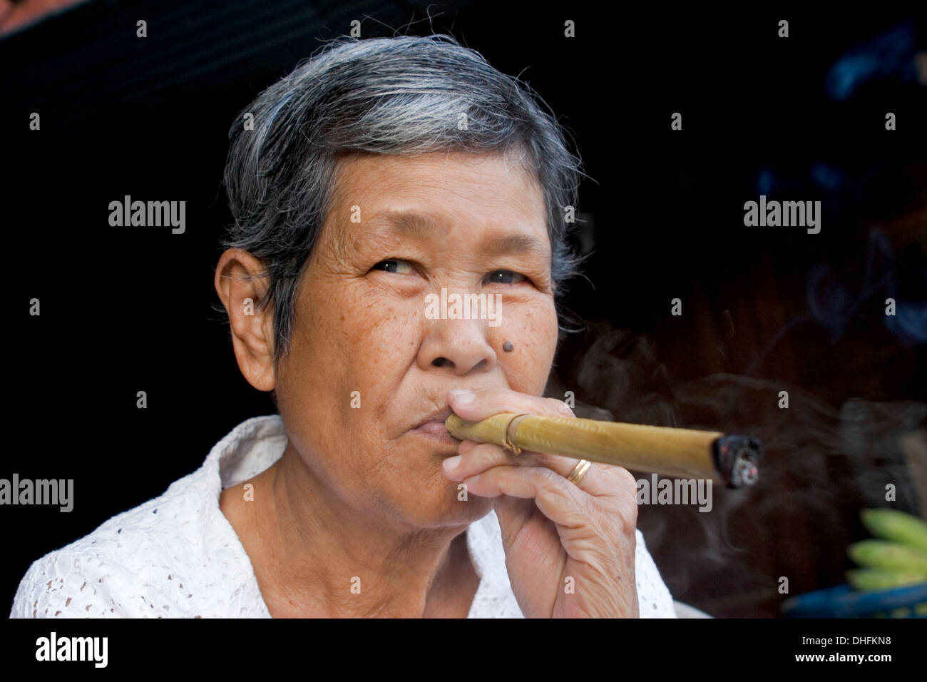 tobacco big cigarette An ethnic woman is smoking a big cigar at her home in Mae Sariang, Thailand  Stock Photo
