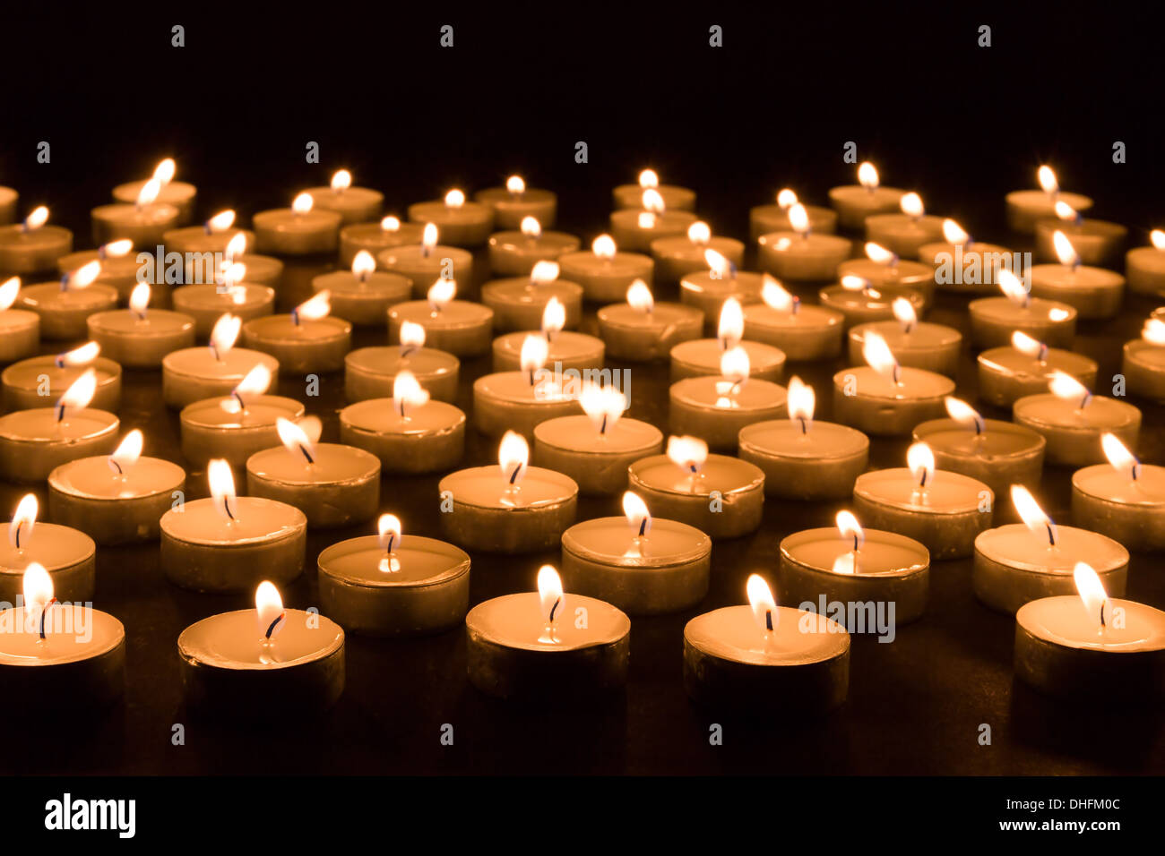 Large group of burning candles at a black background Stock Photo