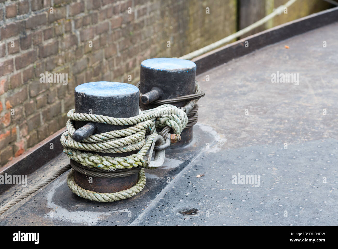 Rope tied to steel bollard on ship deck Stock Photo