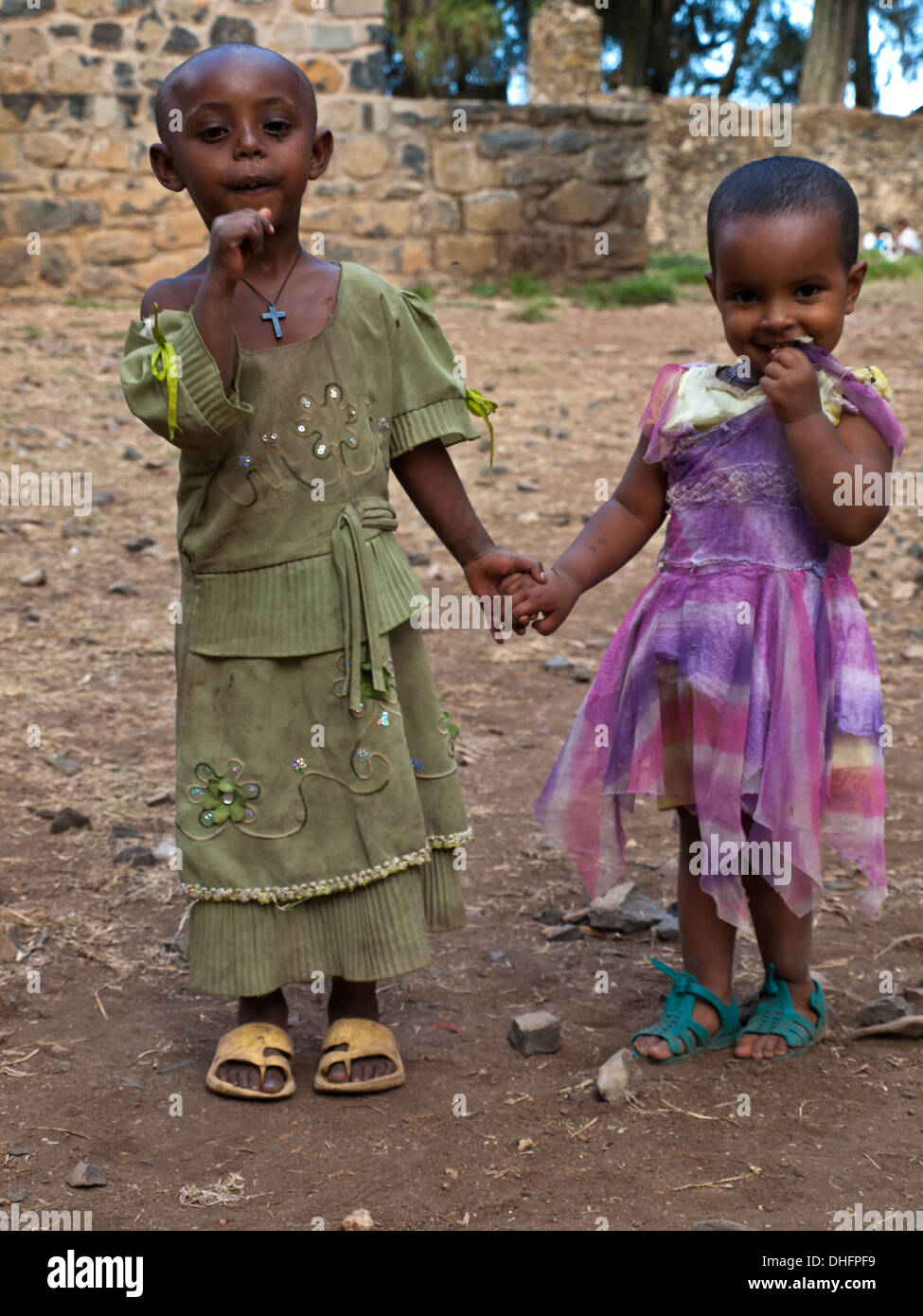 Two Ethiopian girls in poor clothes holding hands Stock Photo