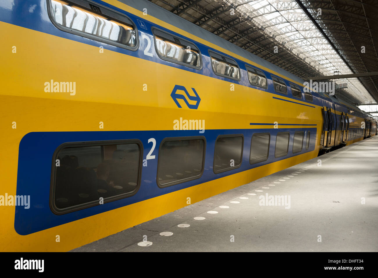 A double-decker train operated by Nederlandse Spoorwegen waiting at Centraal Station, Amsterdam, The Netherlands. Stock Photo
