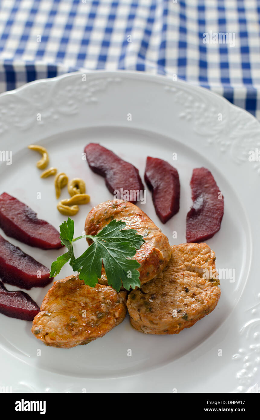 Pork sirloin garnished with apples cooked in wine, mustard and parsley. Stock Photo
