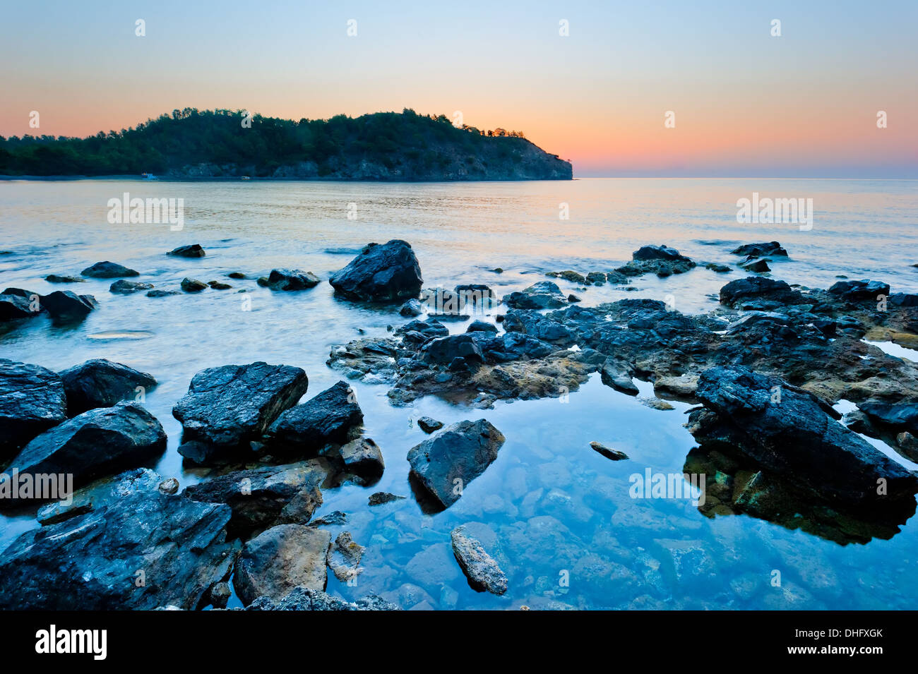 rocky bottom of the sea and the sunrise over the mountains Stock Photo