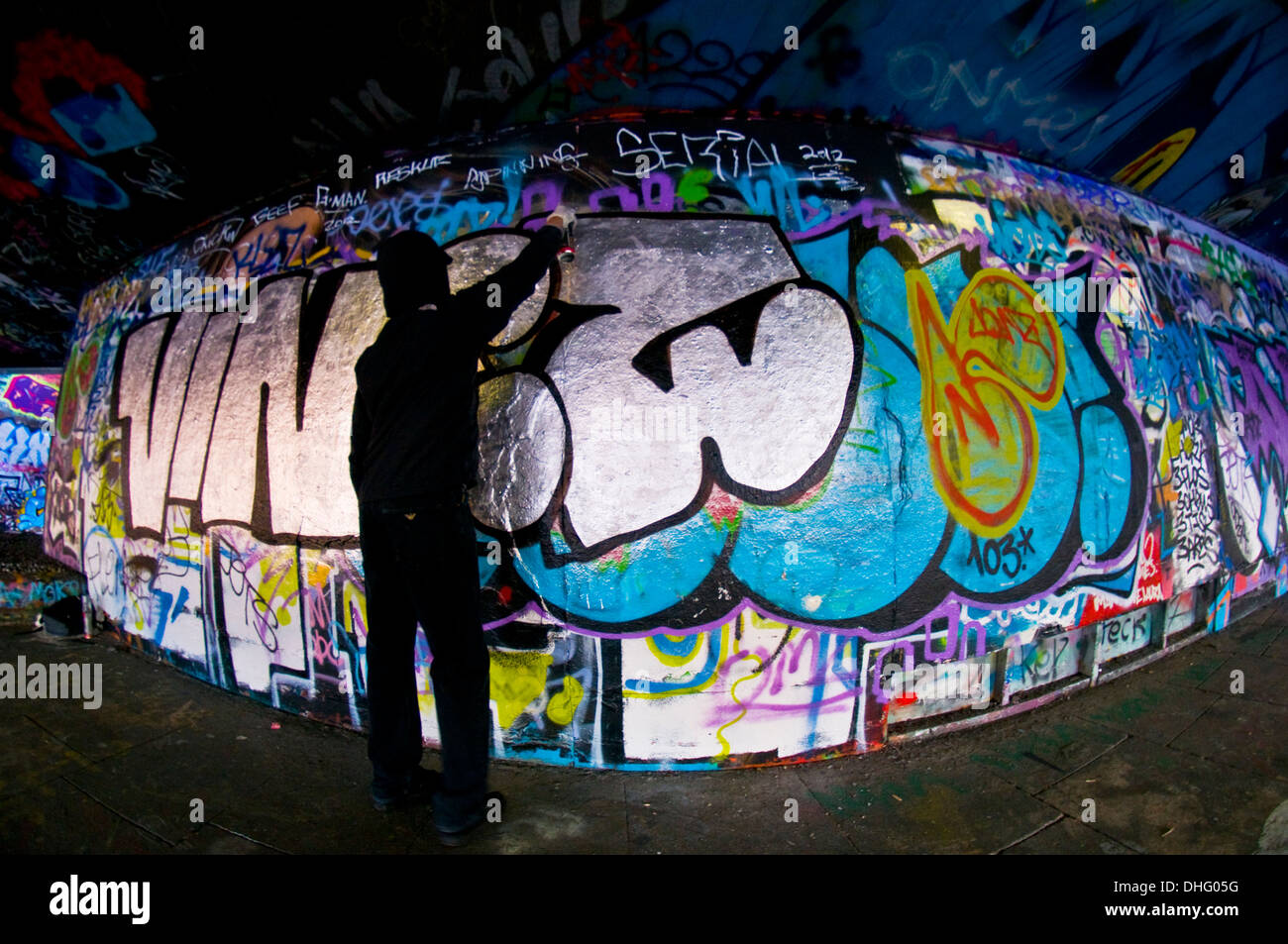 A graffiti artist sprays a wall Stock Photo - Alamy