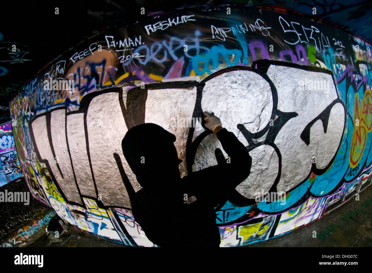 A graffiti artist sprays a wall Stock Photo - Alamy