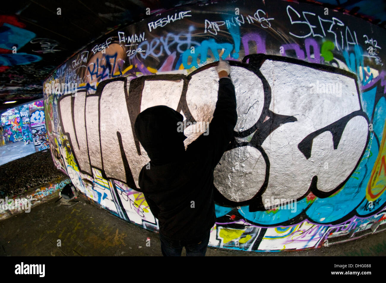 A graffiti artist sprays a wall Stock Photo - Alamy