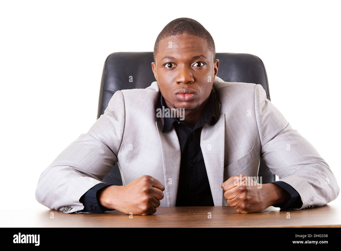 Male businessman sitting in a chair, angry. Madness. Isolated on white.  Stock Photo