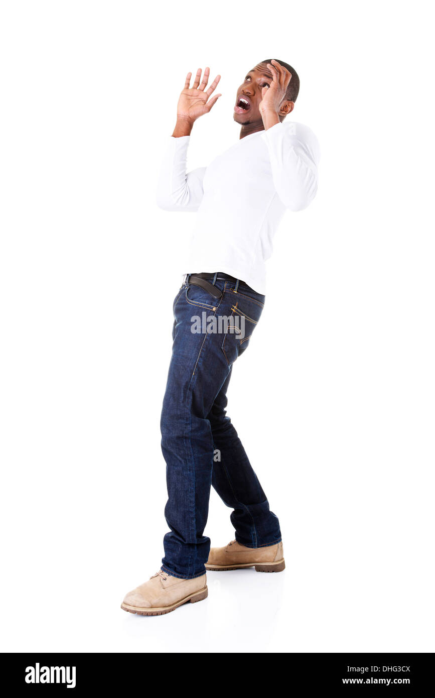 Handsome young man standing, scared. Isolated on white.  Stock Photo