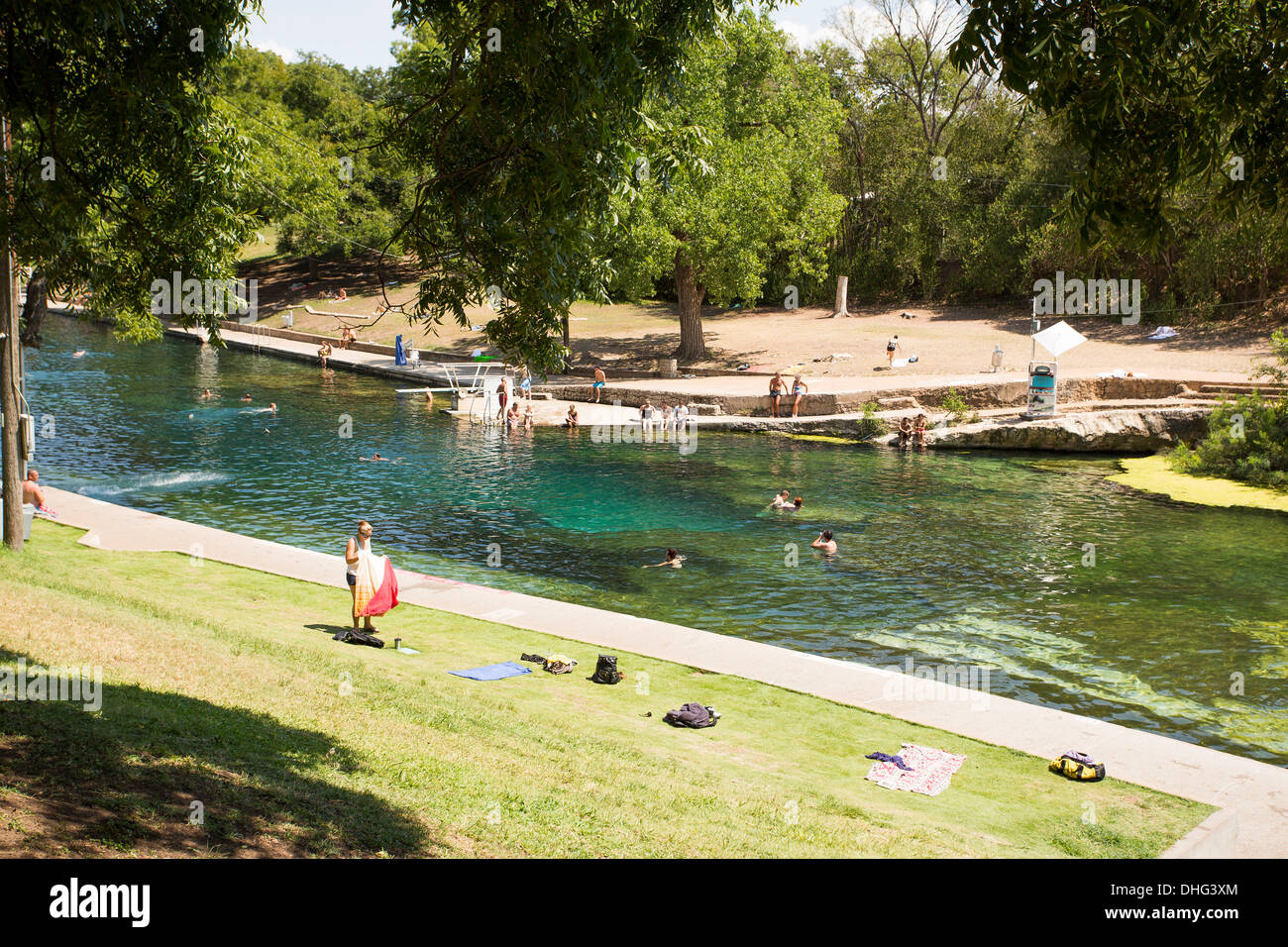 People swim in the outdoor swimming pool at Barton Springs Pool in Austin, Texas, on a hot sunny summer day. Stock Photo