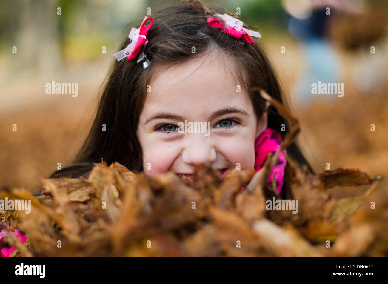 Gorgeous Young Kyri playing in the Autumn leaves at a Paris Park Stock Photo