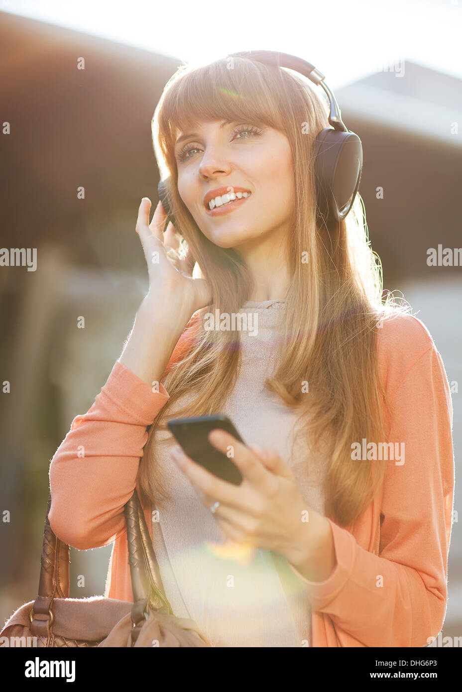 Young beautiful girl listening to MP3 player on the street Stock Photo