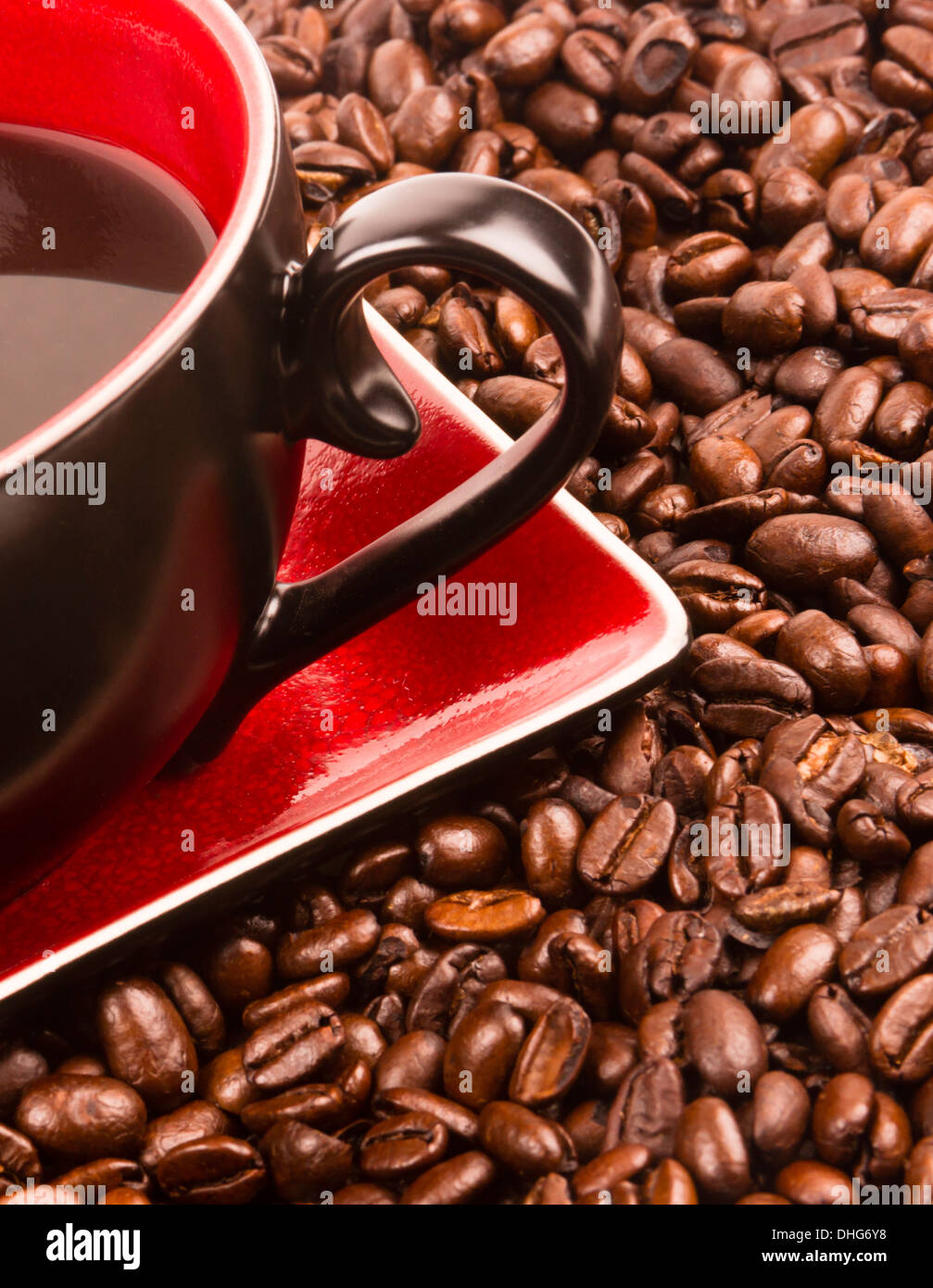 a flat pile group of roasted dark brown coffee beans with cup and saucer Stock Photo