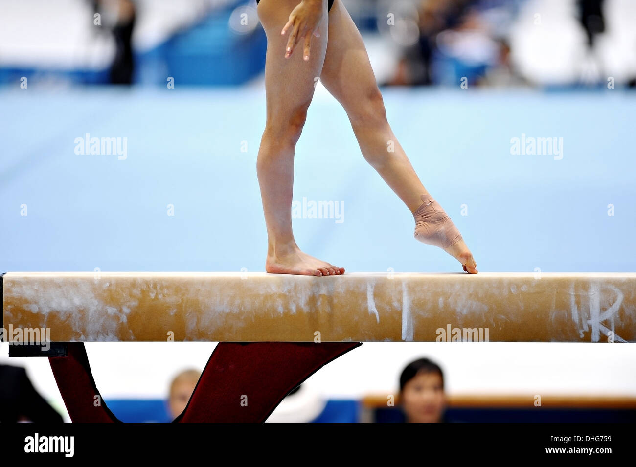 Legs of a gymnast are seen during an exercise on the balance beam apparatus Stock Photo