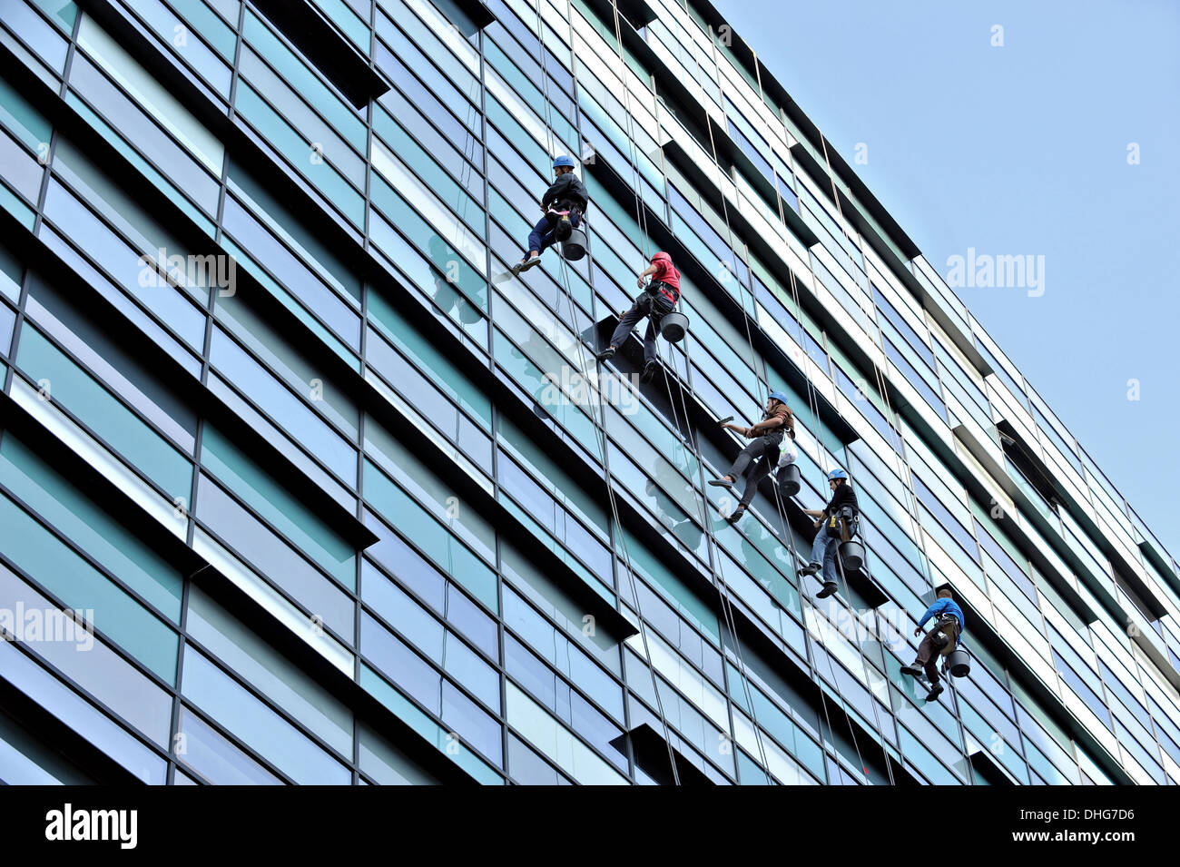 Five window cleaners washing an office building Stock Photo