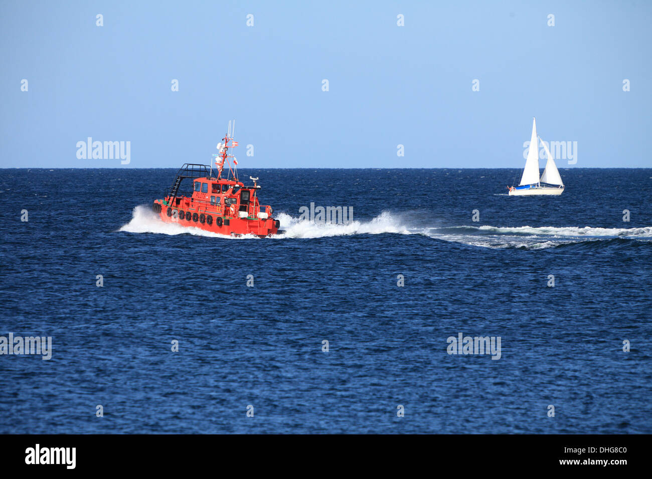 pilot boat orange tugboat at the sea monitors ships Stock Photo