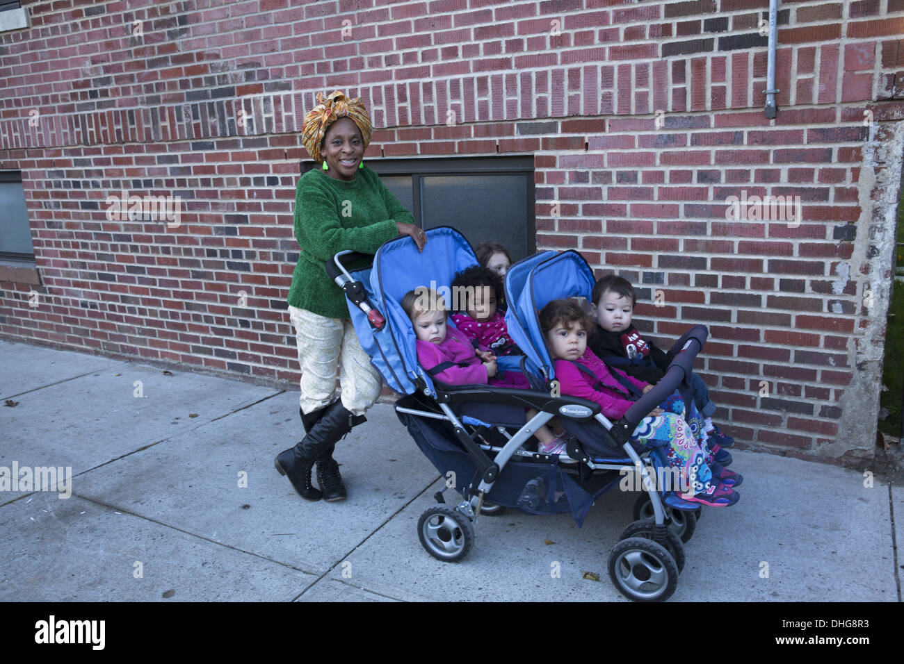 Nursery school teacher with kids on a neighborhood outing in the multicultural Kensington neighborhood of Brooklyn, NY. Stock Photo