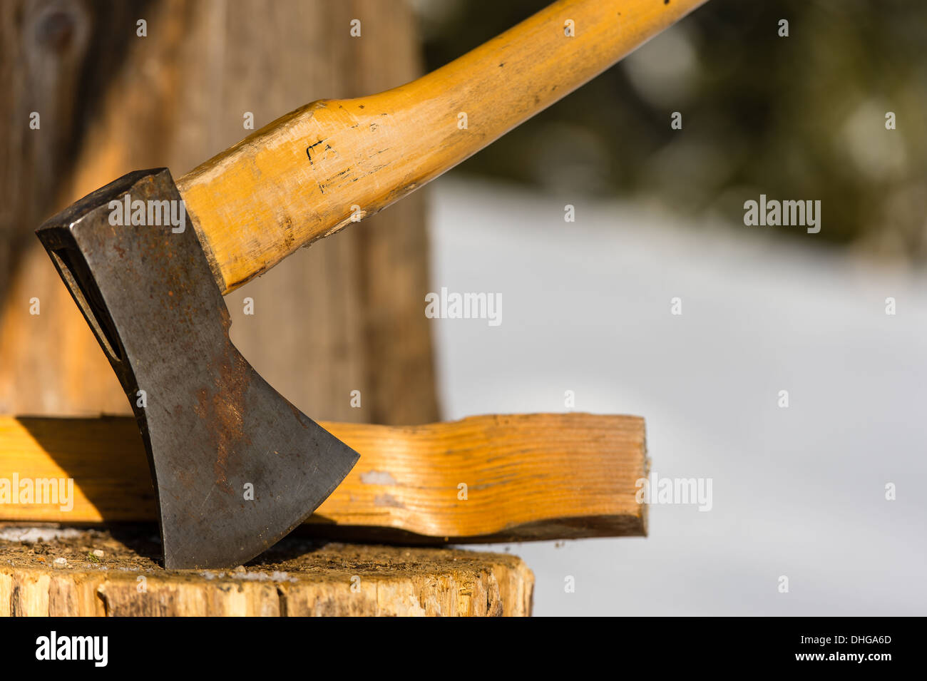 Ax stuck in block of wood winter Stock Photo
