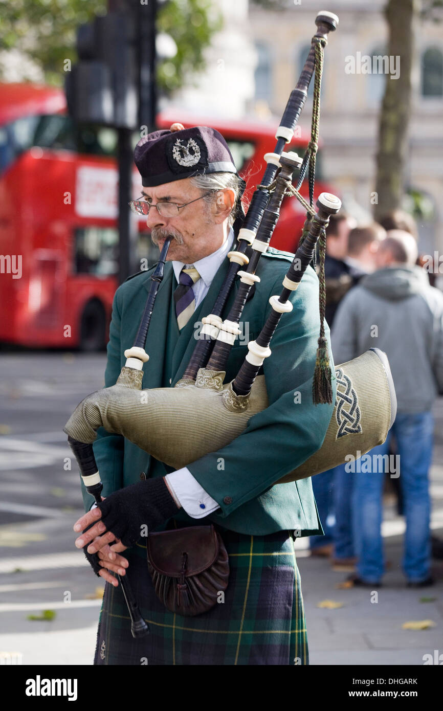 Busker playing the Bagpipes in London entertaining the public Stock