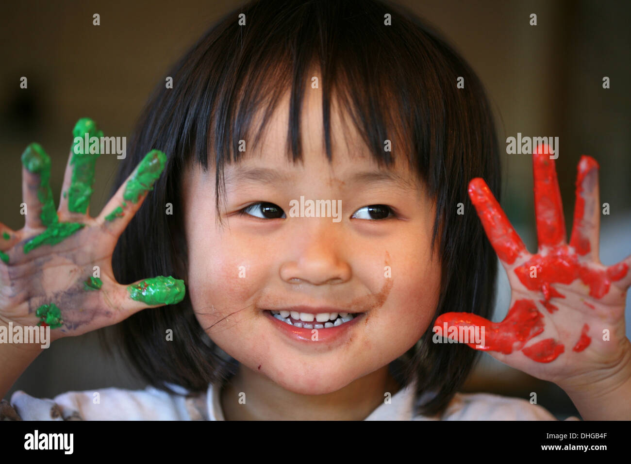 close up of child face playing with finger painting red and green Stock Photo Alamy