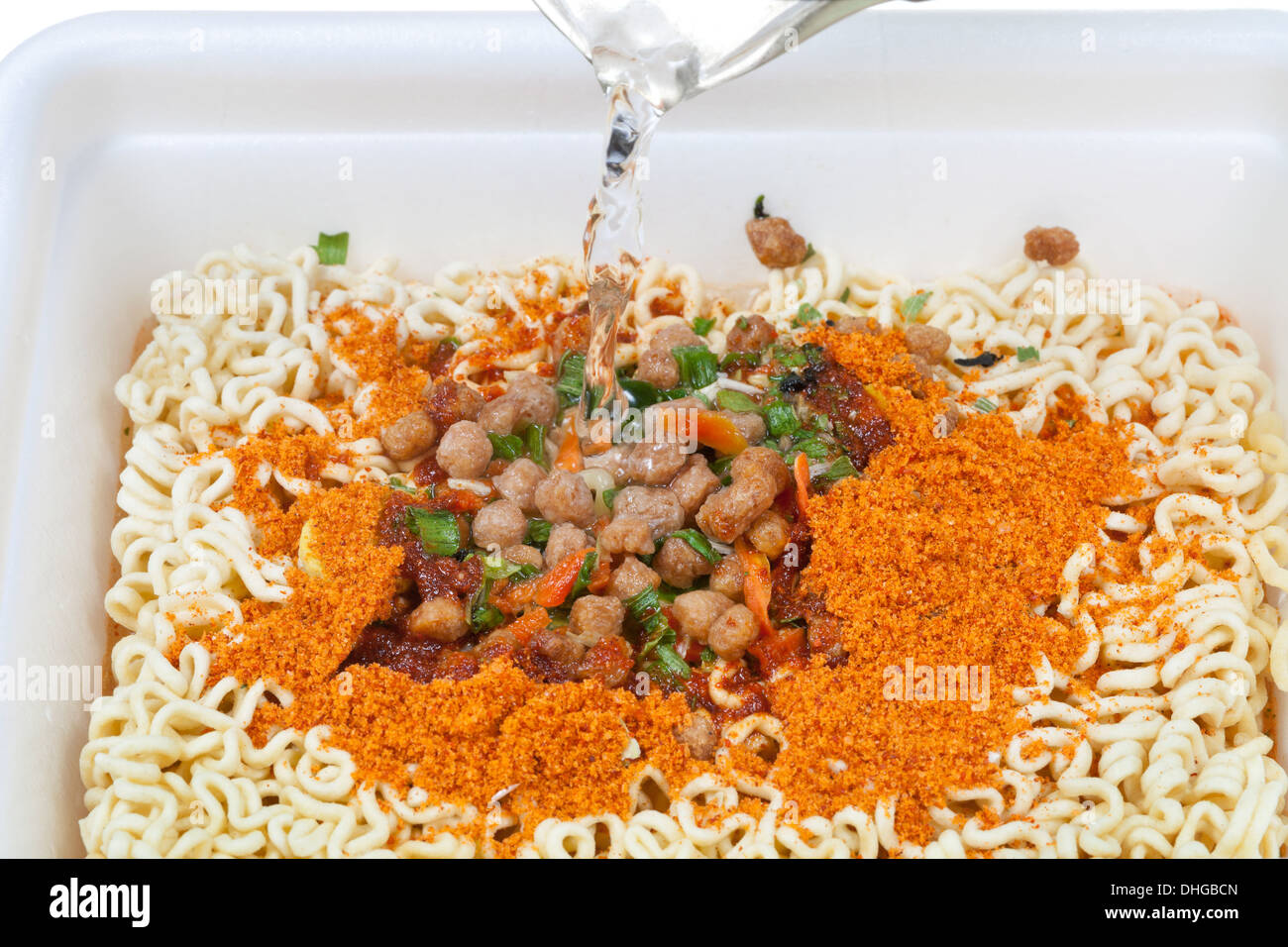cooking of instant ramen with boiling water from the kettle Stock Photo