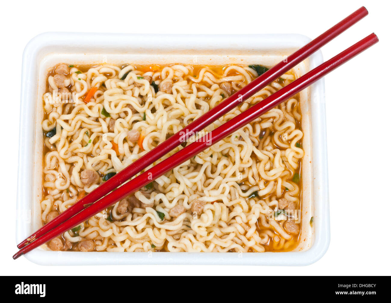 top view of cooked instant noodles and red chopsticks in foam cap isolated on white background Stock Photo