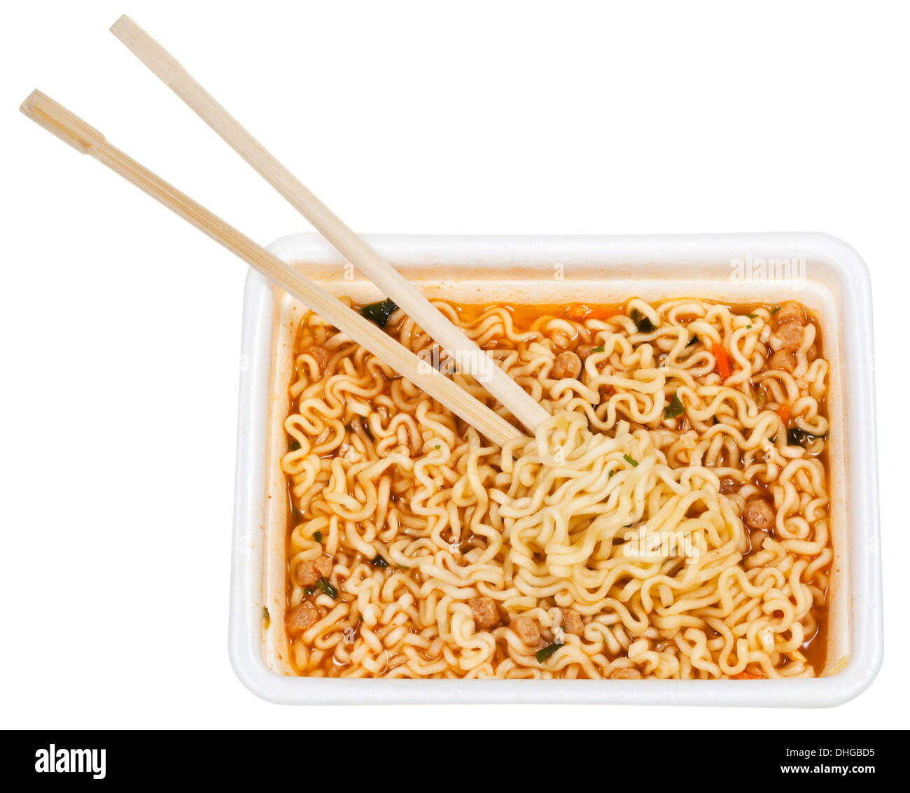 eating of prepared instant noodles by wooden chopsticks from foam cap isolated on white background Stock Photo