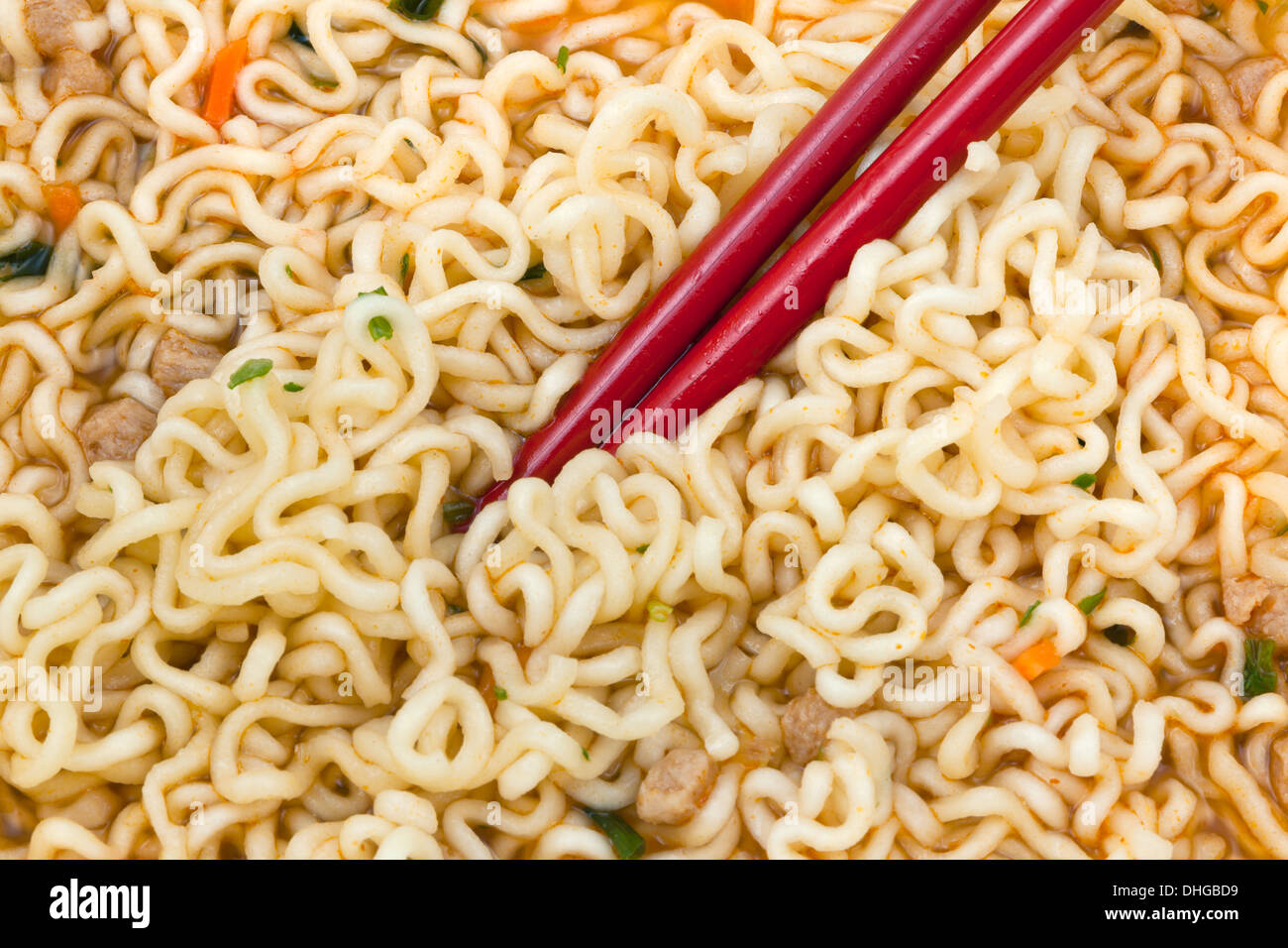 eating of cooked instant noodles by red chopsticks close up Stock Photo