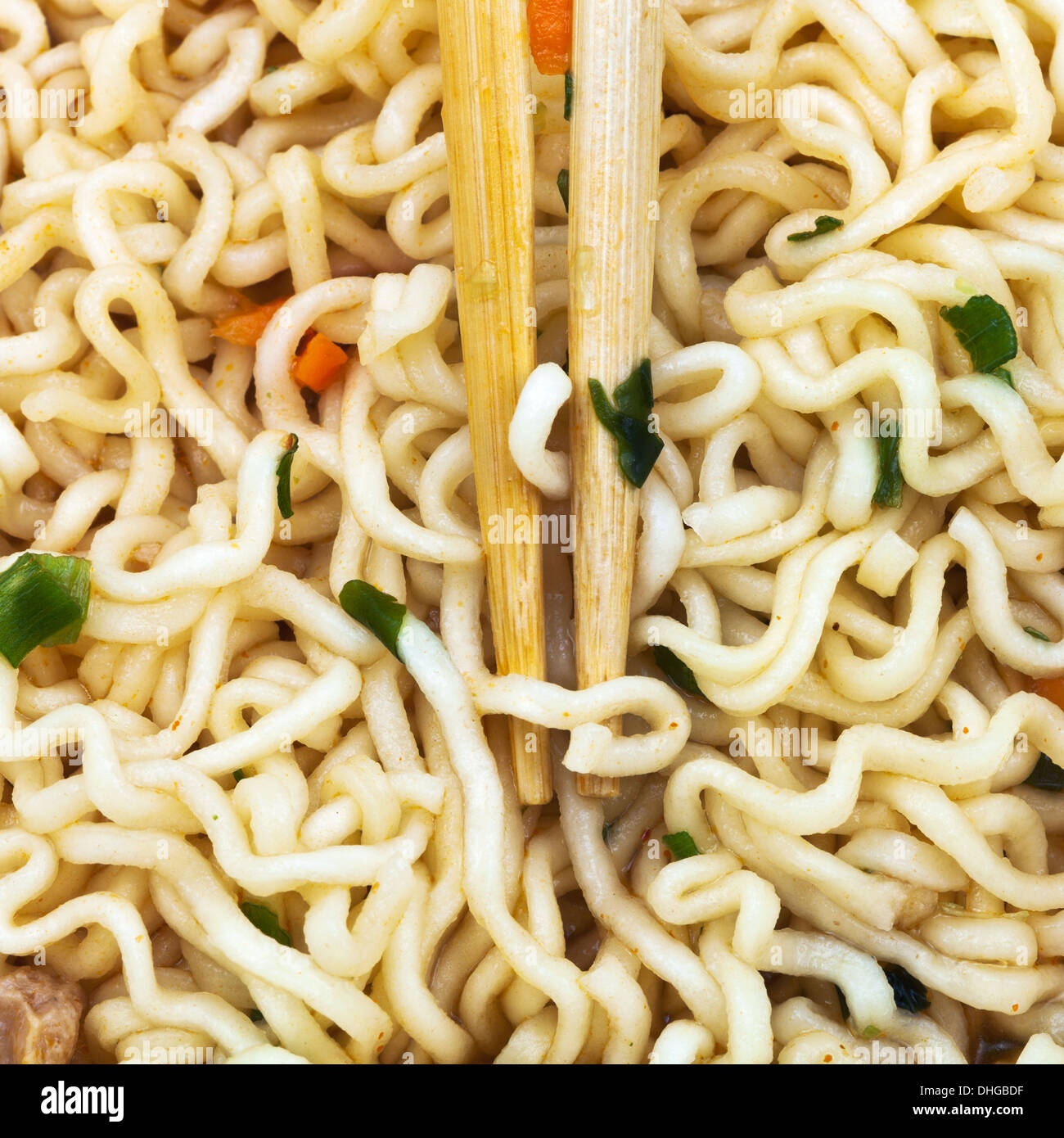 wooden chopsticks on cooked instant ramen close up Stock Photo