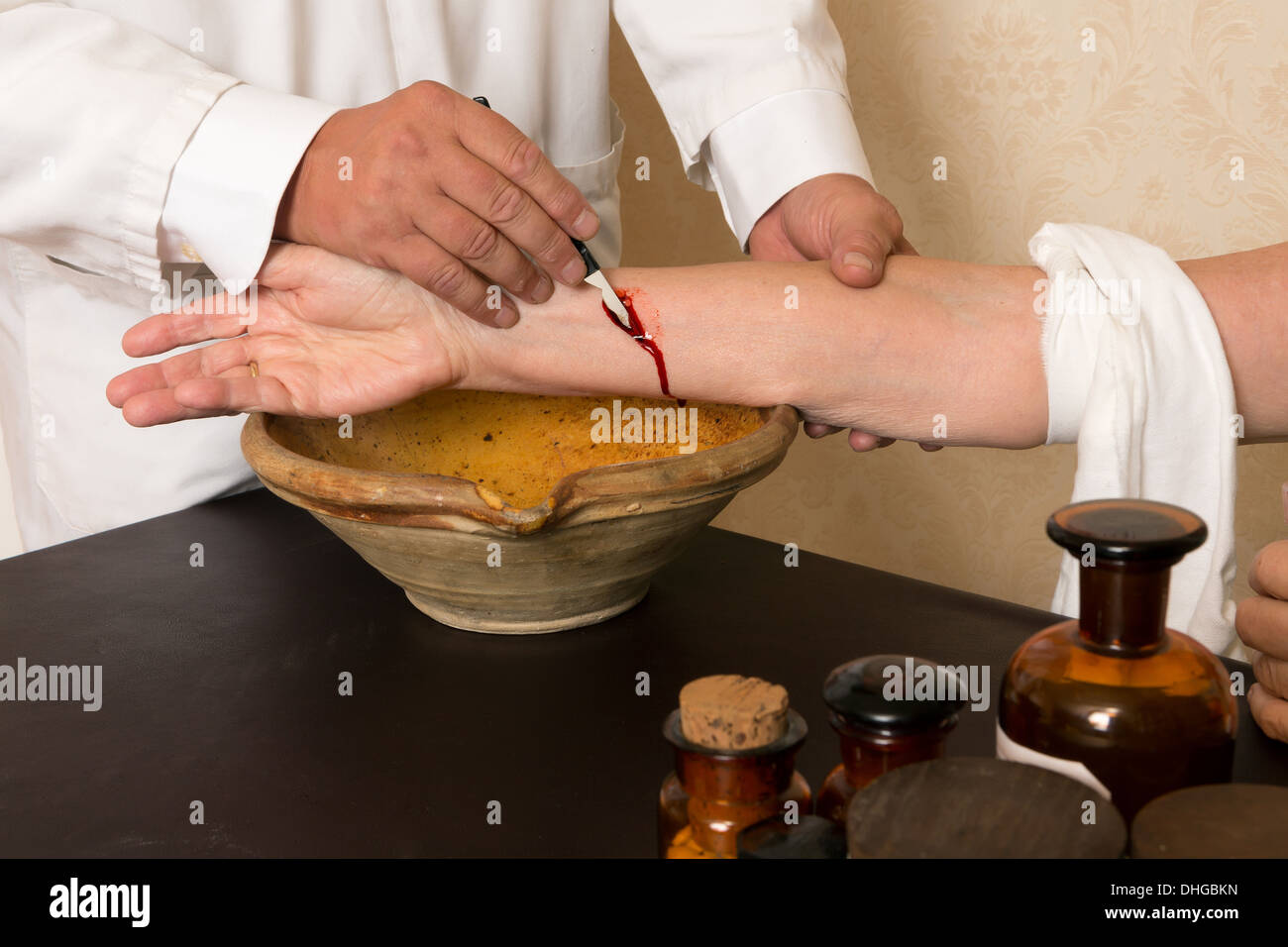 Reenactment of the antique medical procedure of blood letting or bleeding a patient Stock Photo