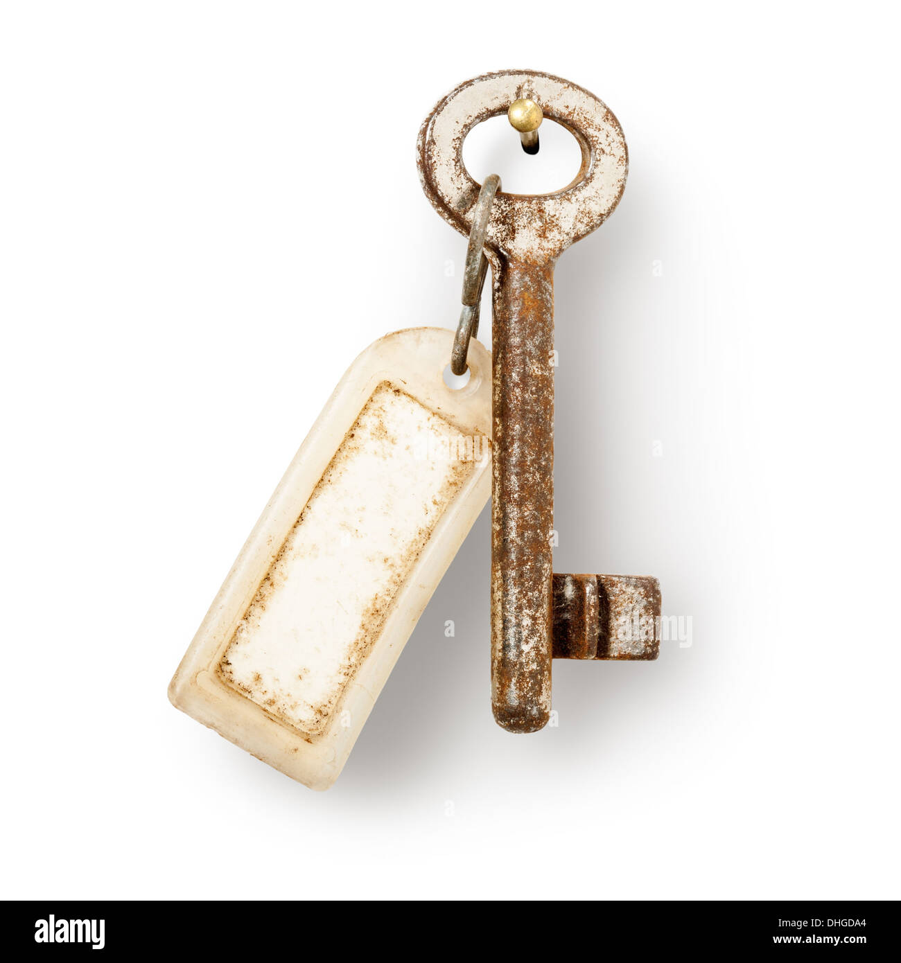 Old key and dirty key fob hanging on nail against white background