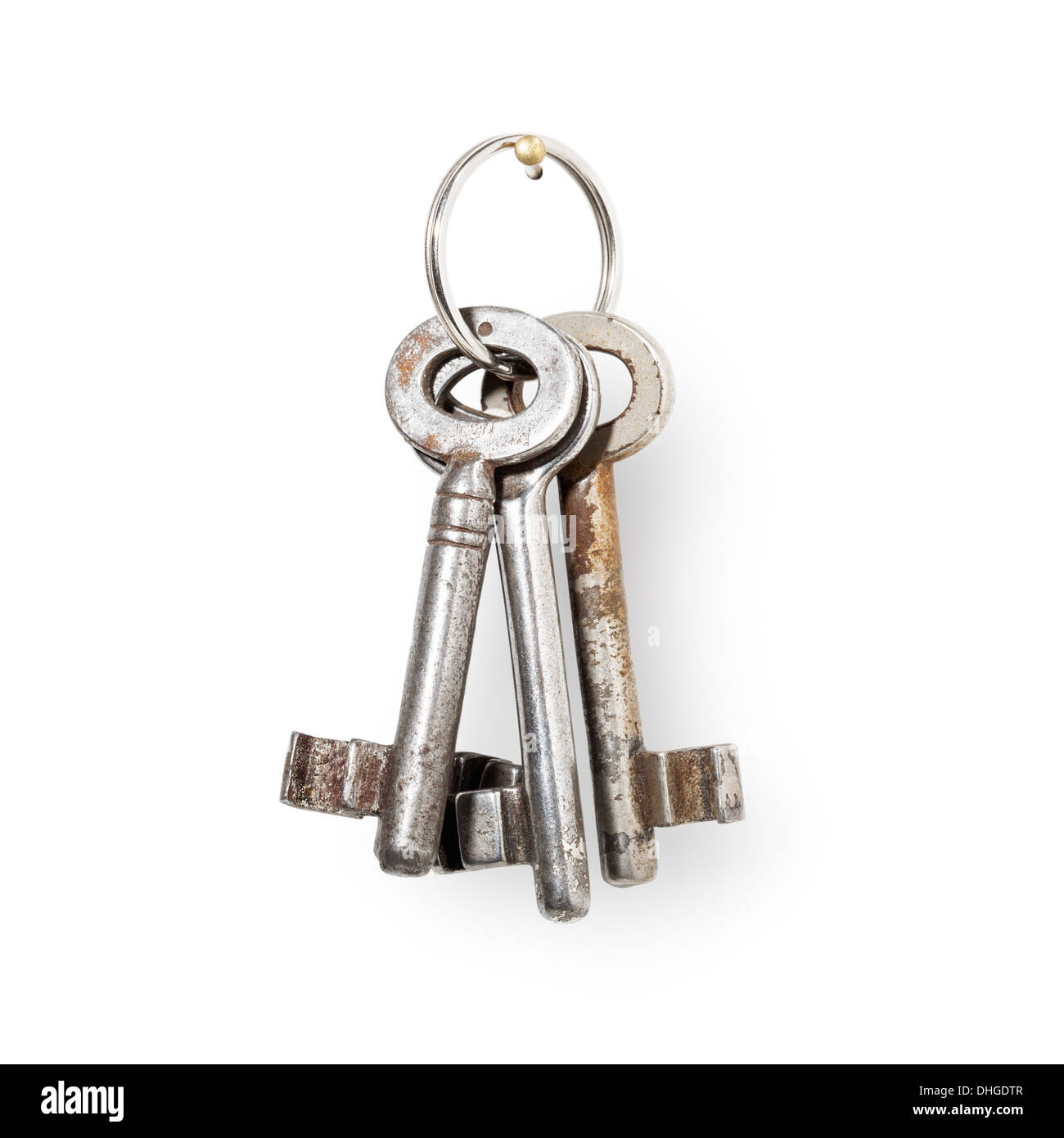 Old rusty house keys with key ring hanging on nail, white background