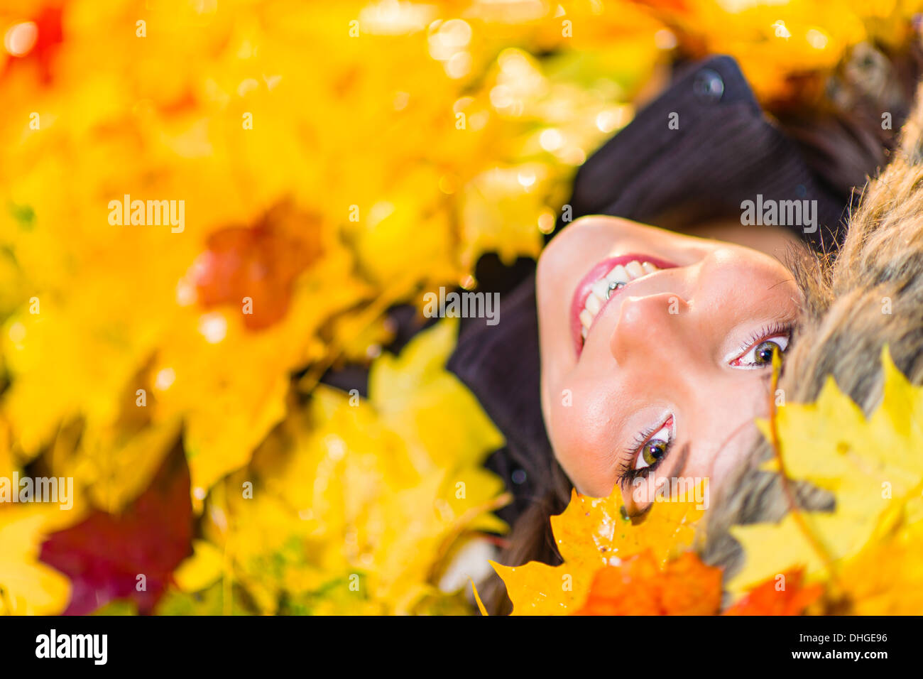 Beautiful girl among of maple leaves on the park Stock Photo - Alamy