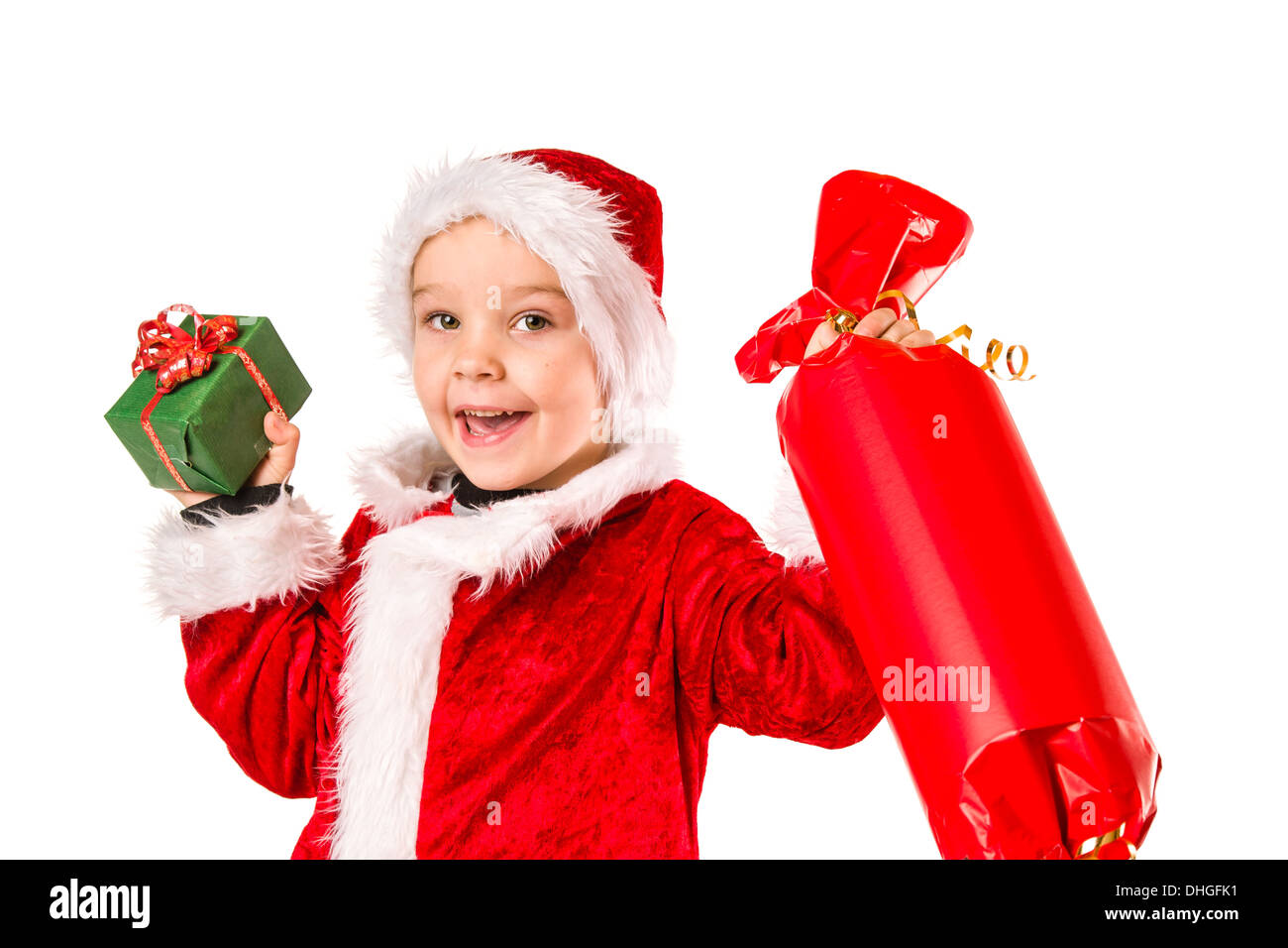 Smiling 5 year old boy wearing Santa Claus costume, Christmas gifts