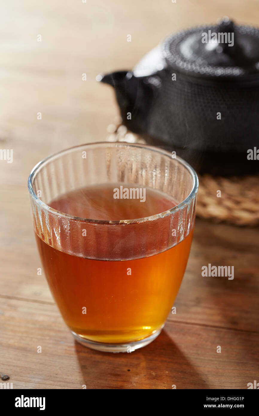 Brown tea on glass cup with black iron tea maker Stock Photo