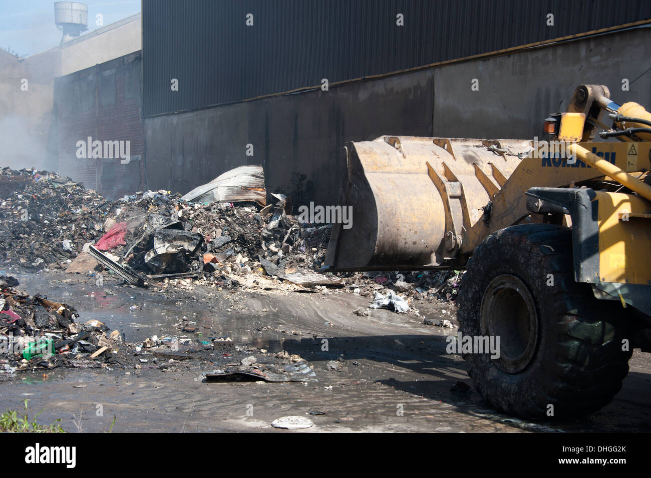Deep seated rubbish fire JCB digger turning over Stock Photo