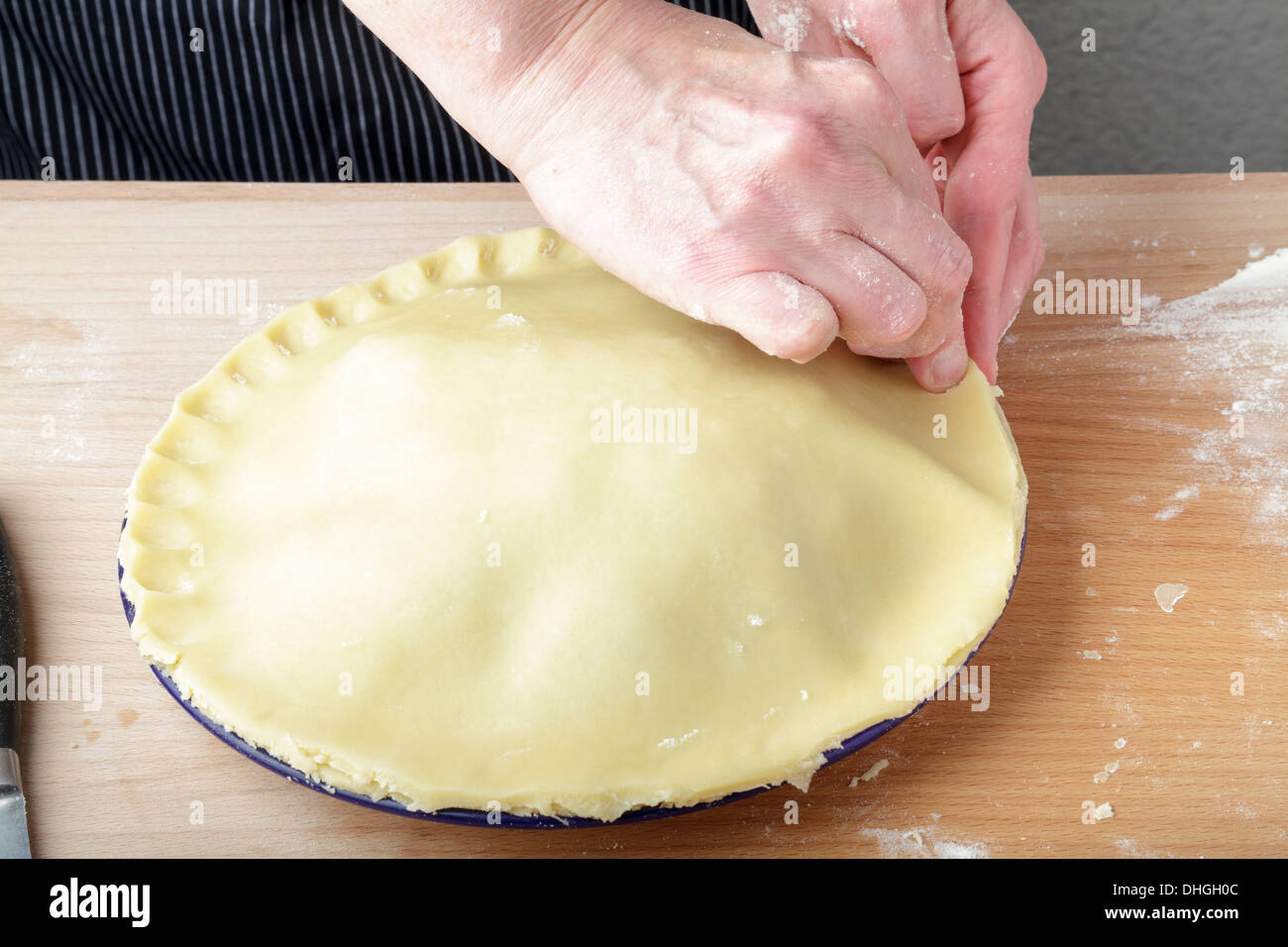 making a plate pie, crimping the edge of the pastry Stock Photo