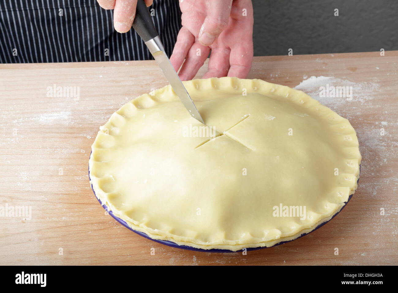 making a plate pie, cutting a cross in the pastry Stock Photo