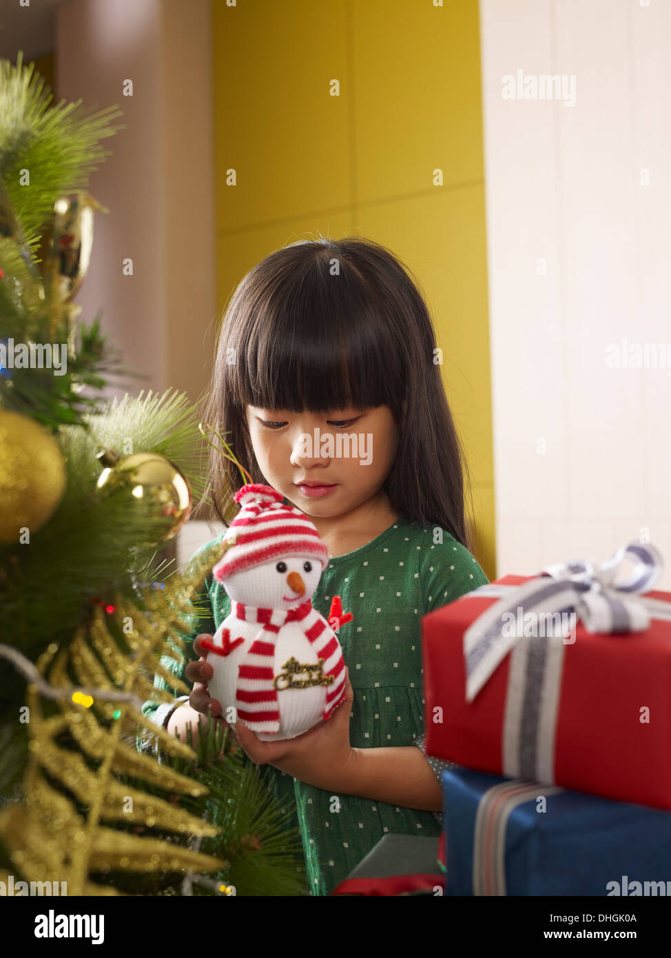 Little Asian girl talking to toy Stock Photo