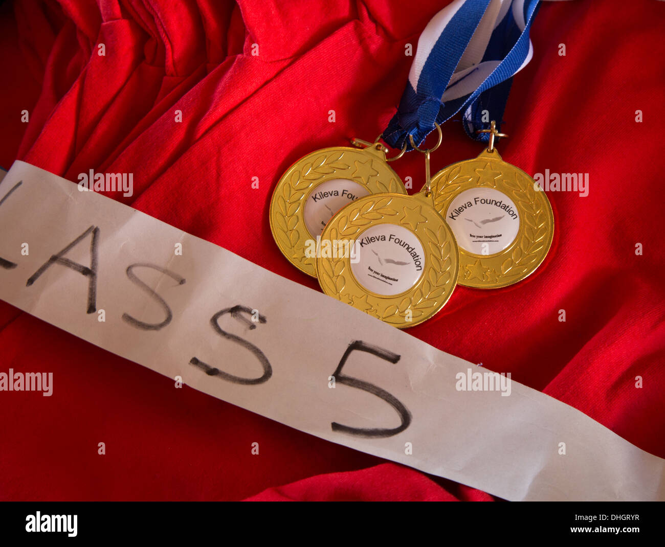 Gold medals and red tee shirts given to high performing children in a Kenyan primary school in Sagalla near the town of Voi Stock Photo