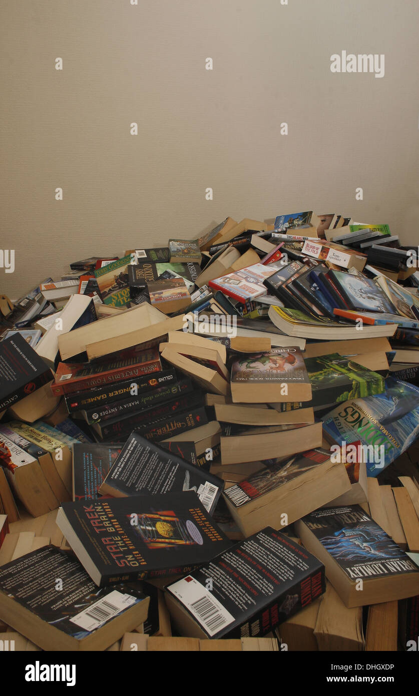 Large pile of books and DVDs on floor of house Stock Photo