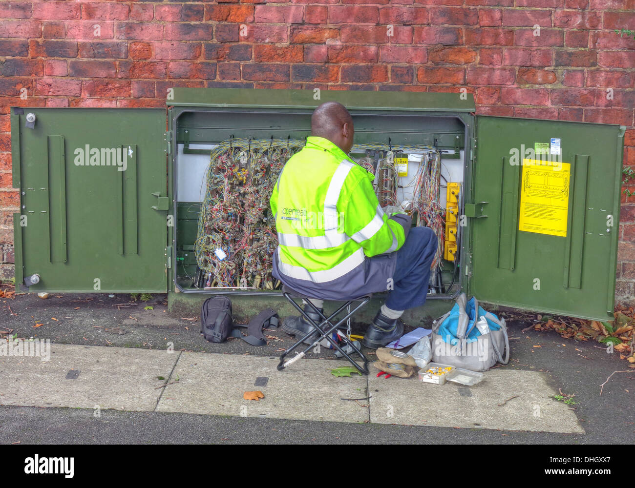 BT Openreach telecoms engineer ,fixing fault, in green roadside cabinet box, Walsall, West Midlands, England, UK Stock Photo