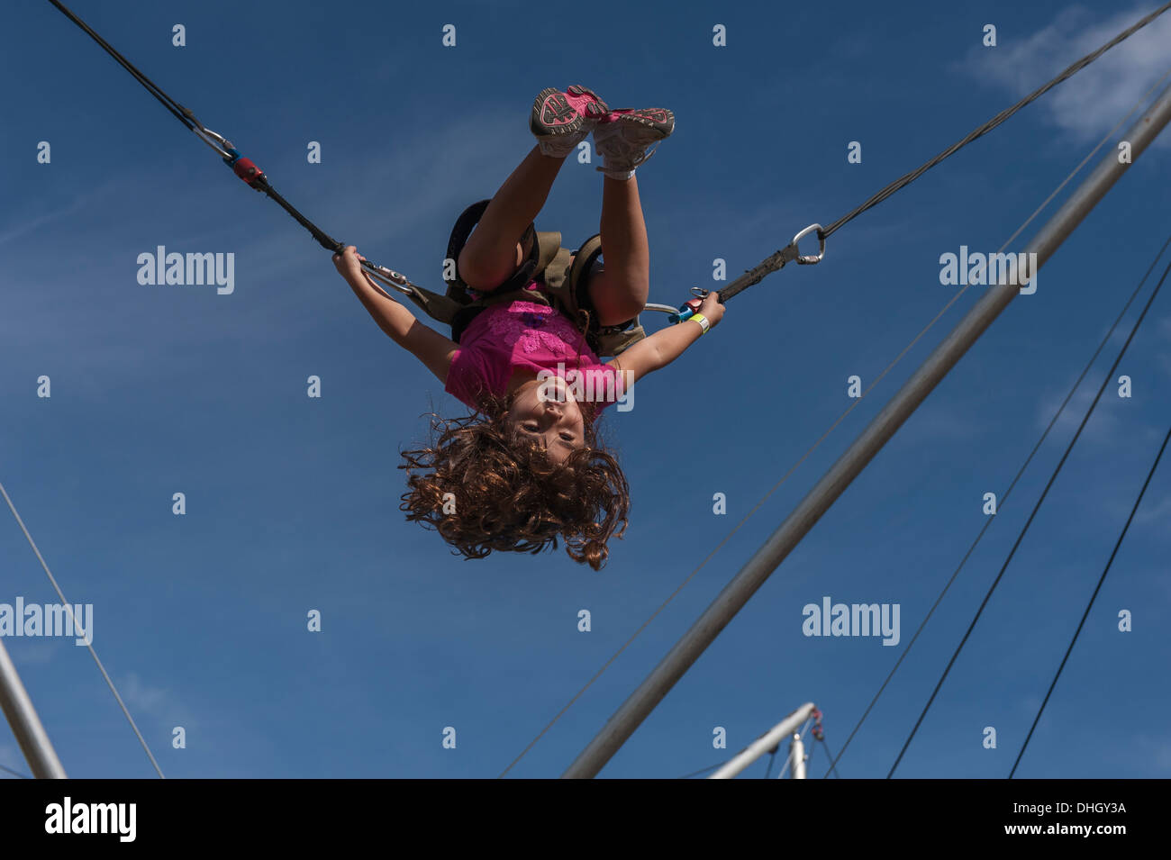 A child swinging on stretchy cords at a local park in Central Florida Stock Photo