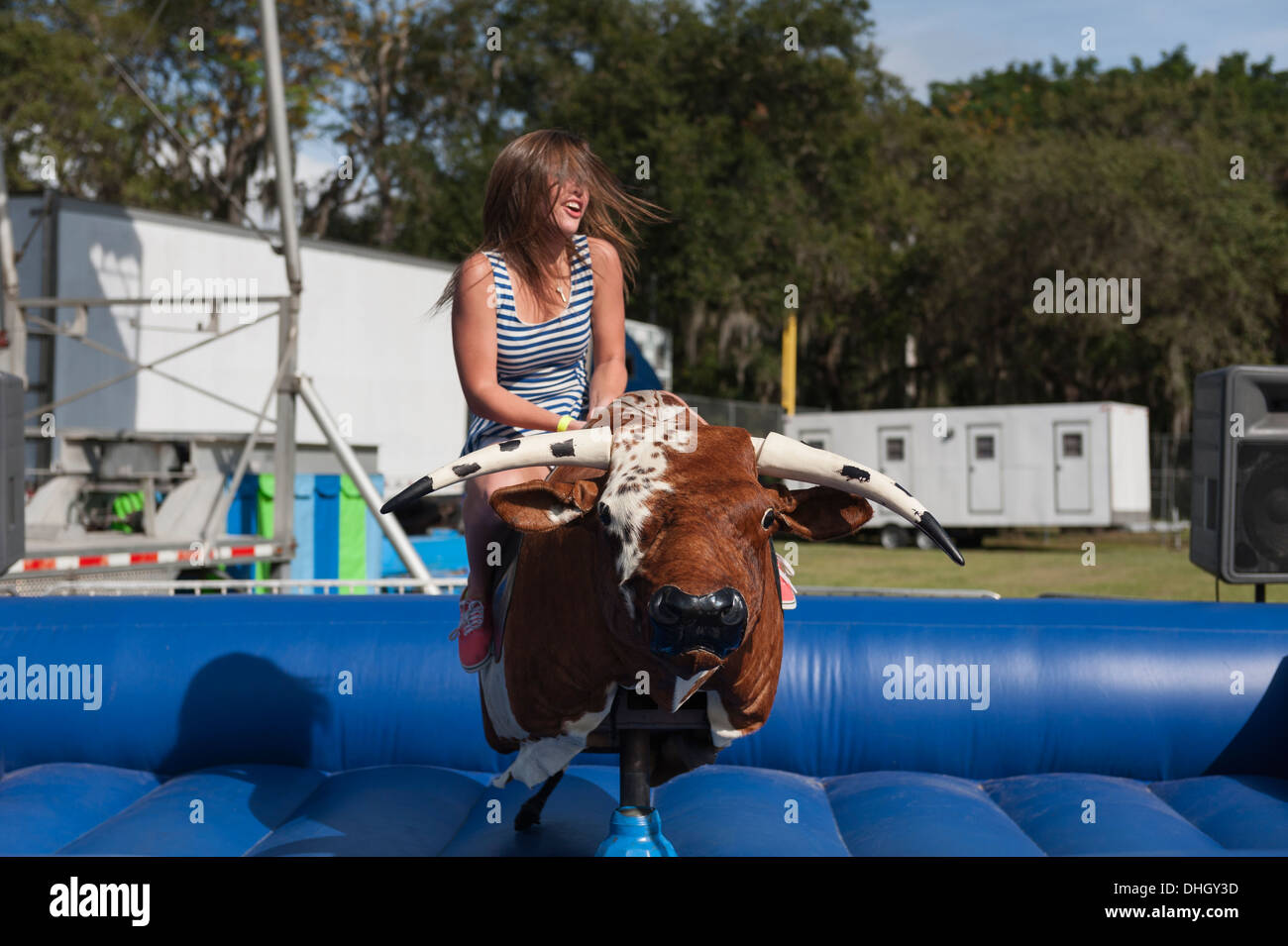 A teenager riding a mechanical Bull at a Carnival in Central Florida USA Stock Photo