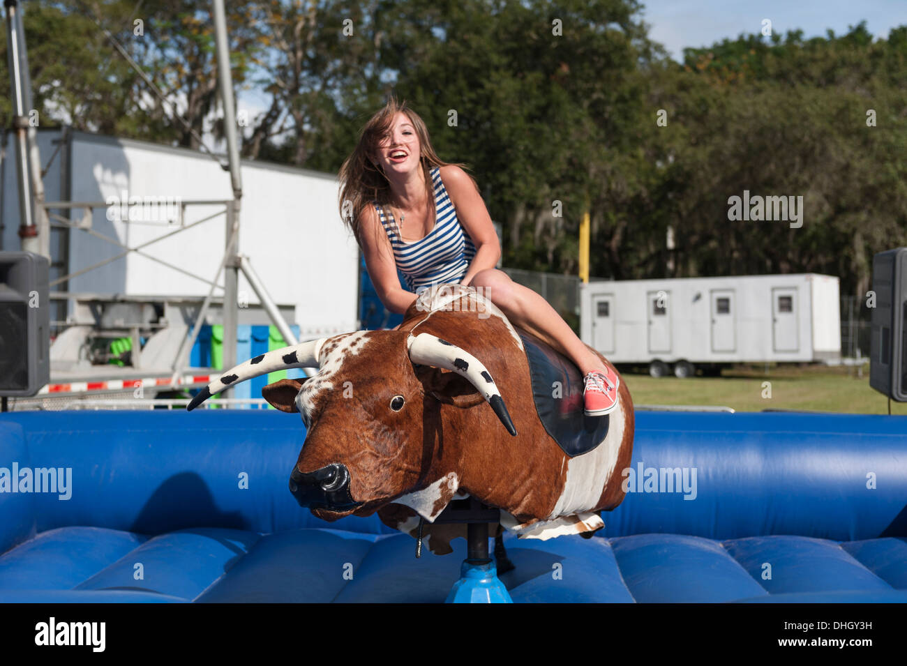 A teenager riding a mechanical Bull at a Carnival in Central Florida USA Stock Photo