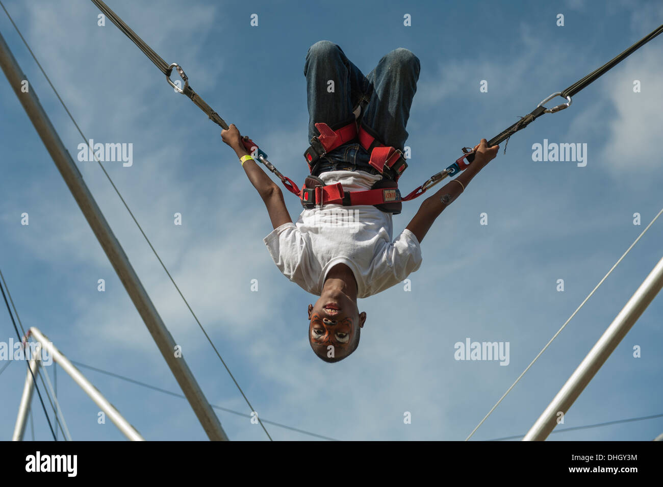 A child swinging on stretchy cords at a local park in Central Florida Stock Photo